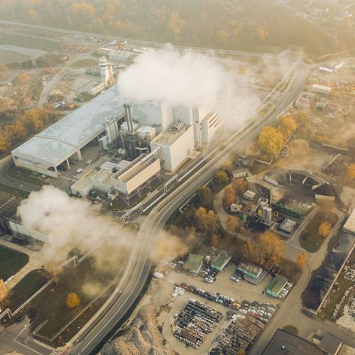 An overhead view of a factory emitting gasses into the atmosphere.